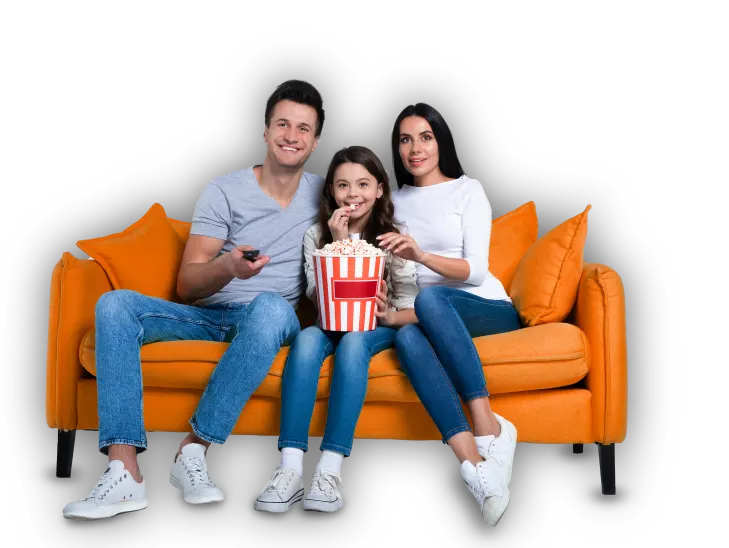 A family wahtching a tv on couch while snacking on delicious popcorn corns